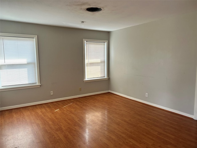 empty room with wood-type flooring and a wealth of natural light