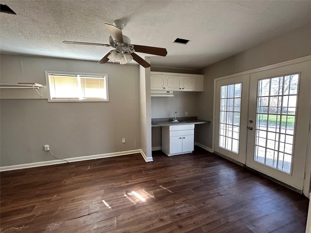 kitchen featuring dark hardwood / wood-style floors, white cabinetry, sink, a healthy amount of sunlight, and french doors