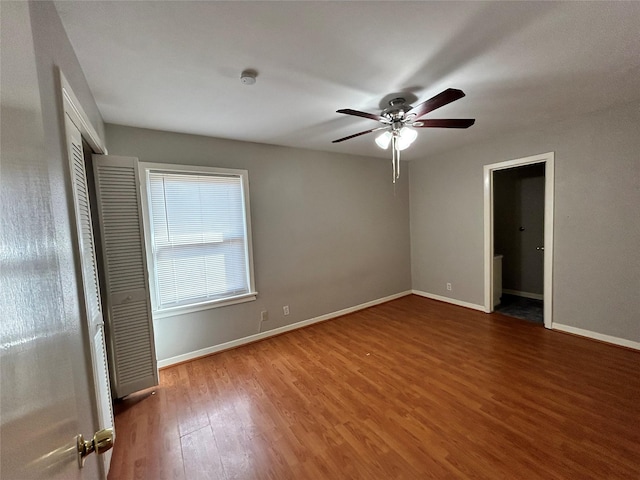 unfurnished bedroom featuring ceiling fan, wood-type flooring, and a closet