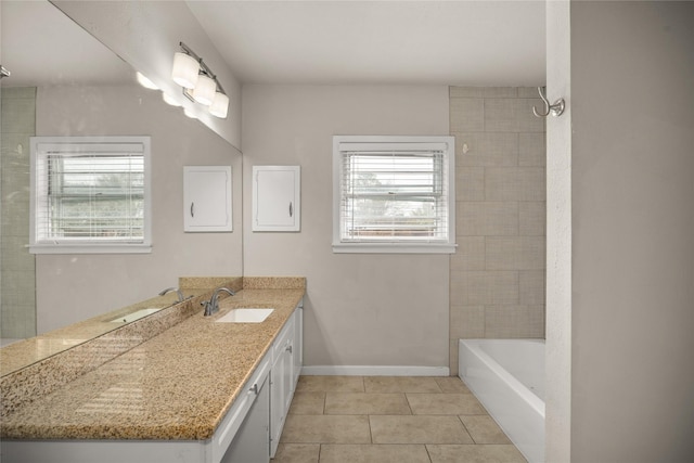 bathroom with vanity, tiled shower / bath combo, and tile patterned flooring