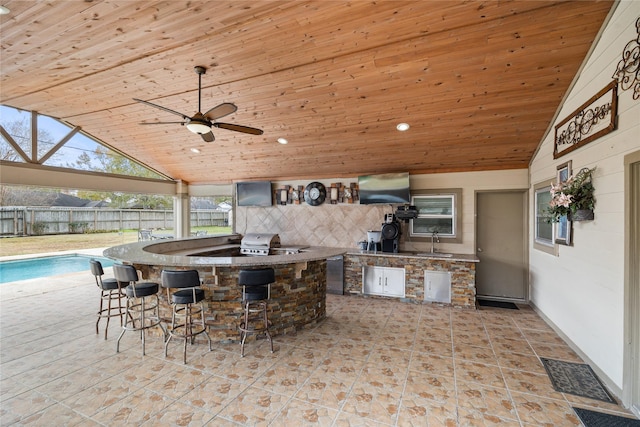 view of patio / terrace with a fenced in pool, area for grilling, exterior kitchen, and a wet bar