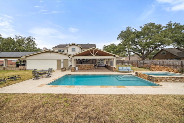 view of pool with an in ground hot tub, a gazebo, a patio area, and a lawn