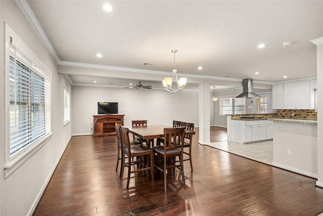 dining room with crown molding, dark hardwood / wood-style floors, and a chandelier