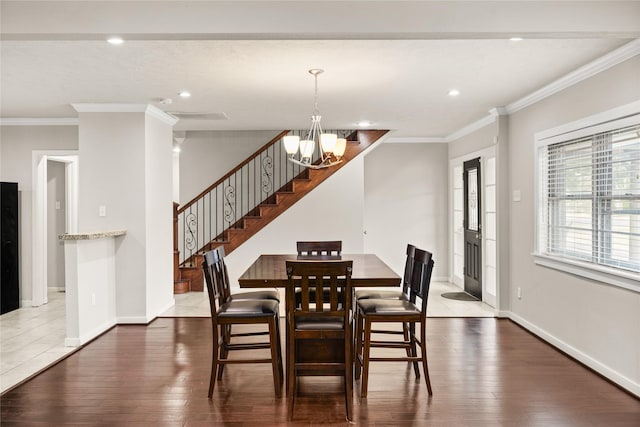 dining area featuring dark hardwood / wood-style flooring, ornamental molding, and a chandelier