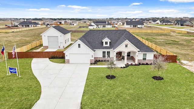 view of front of house with a garage, covered porch, and a front yard