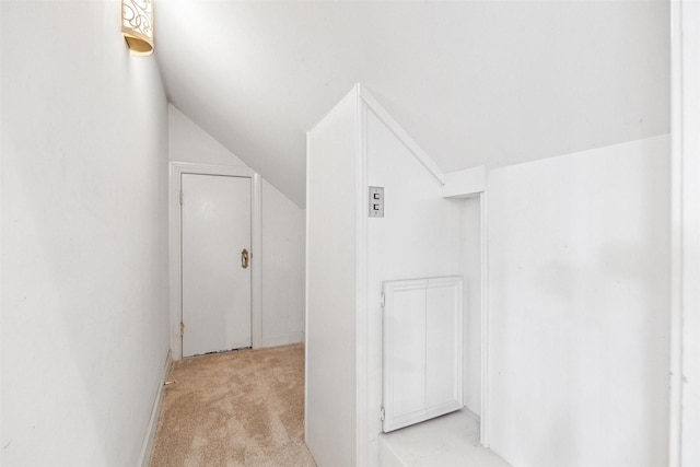 interior space featuring vaulted ceiling and light colored carpet