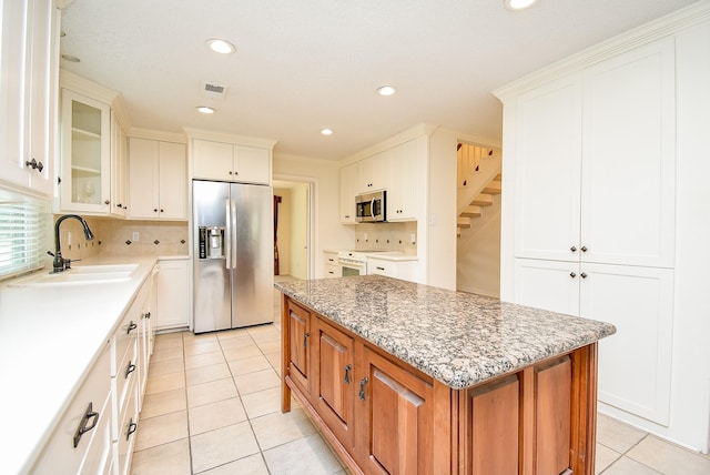 19431 Joanleigh Dr, Spring, TX 77388 - kitchen featuring decorative backsplash, a center island, a sink, appliances with stainless steel finishes, and light tile patterned floors