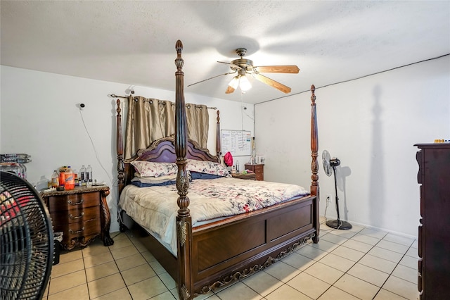 tiled bedroom with ceiling fan and a textured ceiling