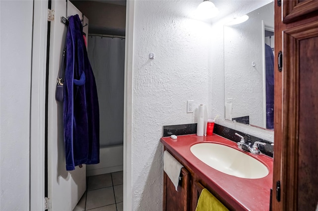 bathroom with shower / tub combo with curtain, tile patterned floors, and vanity