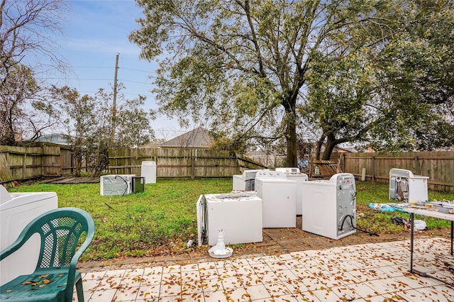 view of yard featuring washing machine and dryer and a patio