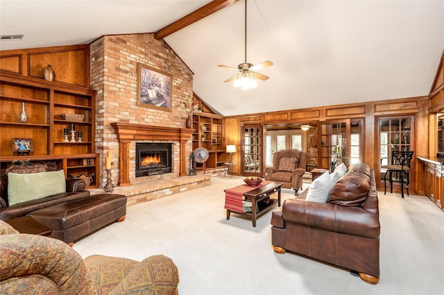 living room featuring wood walls, a fireplace, visible vents, and light colored carpet