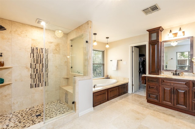 bathroom featuring a wealth of natural light, a stall shower, vanity, and visible vents