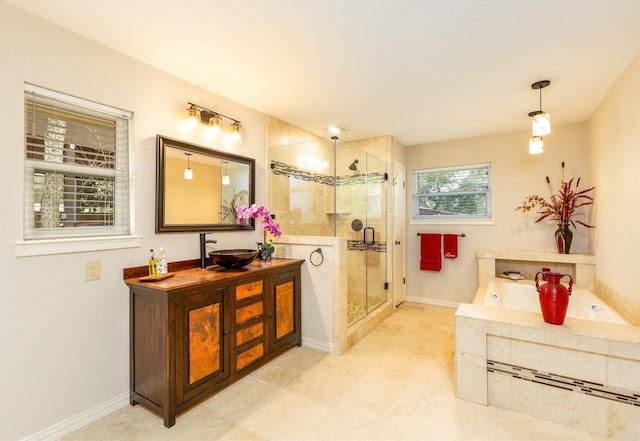 full bathroom featuring a sink, baseboards, a bath, double vanity, and a stall shower