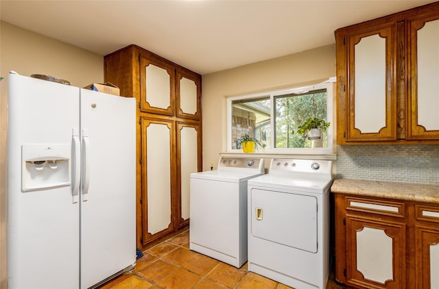 washroom with light tile patterned flooring, cabinet space, and washer and dryer