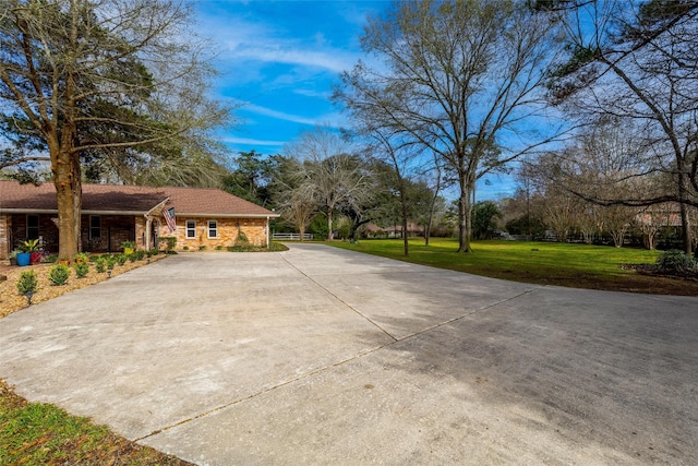 view of side of property featuring driveway and a lawn