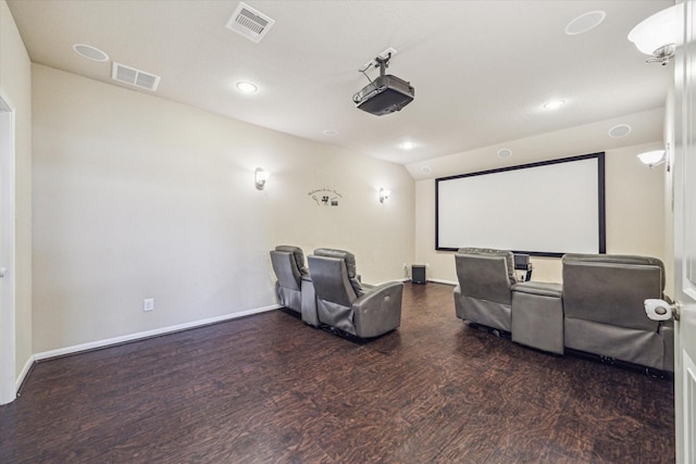 home theater featuring dark wood-style flooring, visible vents, and baseboards