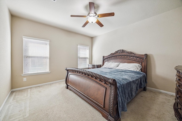 bedroom with light carpet, ceiling fan, and baseboards