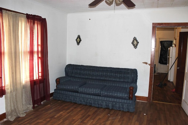 sitting room featuring dark wood-type flooring, ceiling fan, and ornamental molding