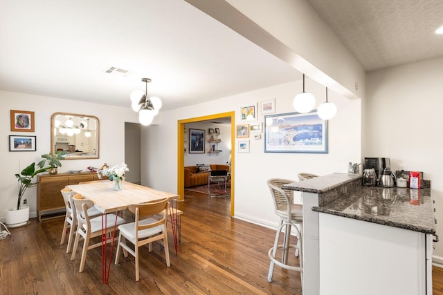 dining area featuring indoor bar and dark hardwood / wood-style floors