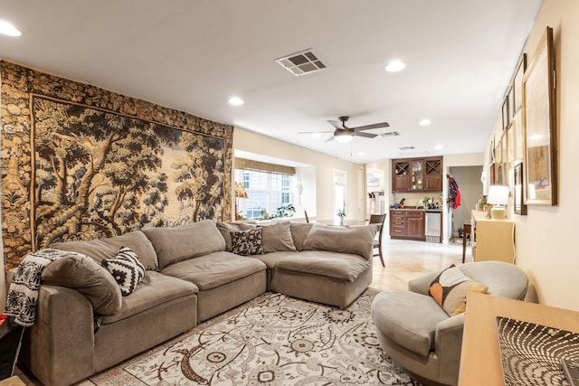 living room with ceiling fan and bar area