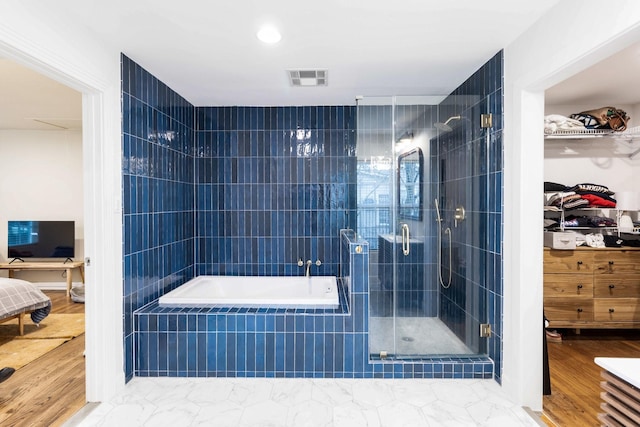 bathroom featuring hardwood / wood-style flooring and independent shower and bath