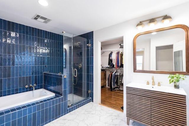 bathroom featuring vanity and shower with separate bathtub