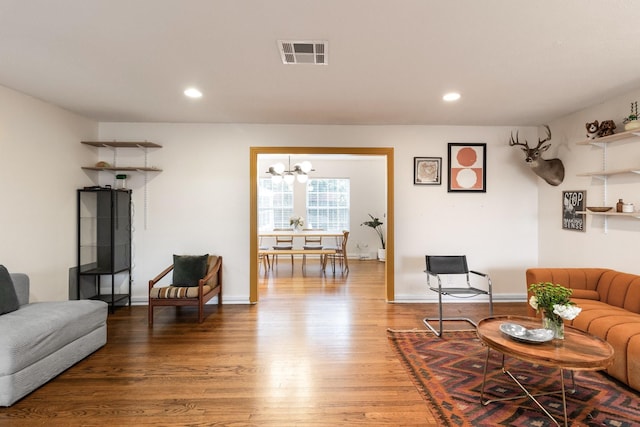 living room with hardwood / wood-style floors and an inviting chandelier