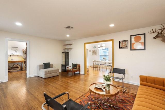 living room with hardwood / wood-style floors and a notable chandelier