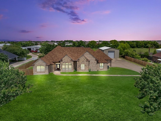 view of front of home with a garage, an outbuilding, and a lawn