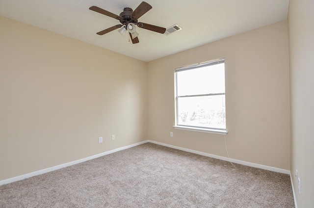 spare room with ceiling fan and carpet