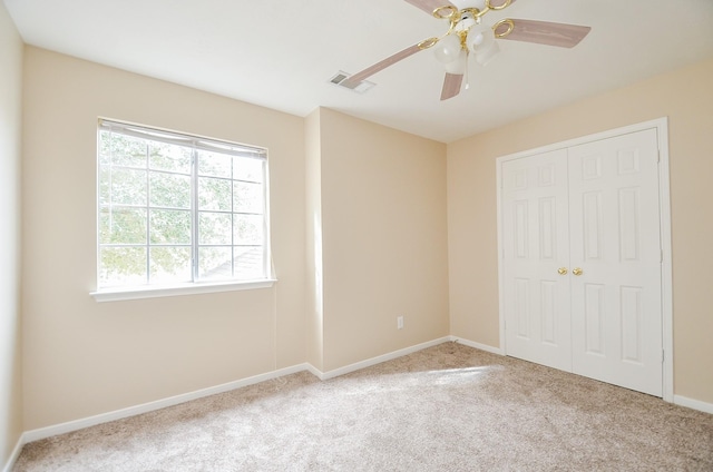 unfurnished bedroom featuring light colored carpet, a closet, and ceiling fan