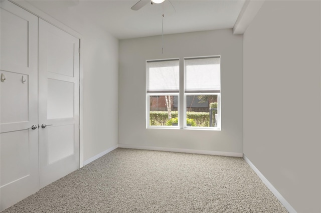 empty room featuring ceiling fan, baseboards, and speckled floor