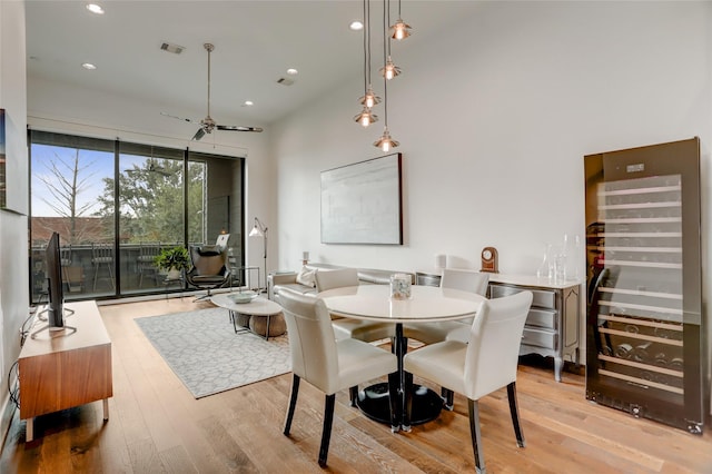 dining space with wine cooler, visible vents, recessed lighting, and wood finished floors