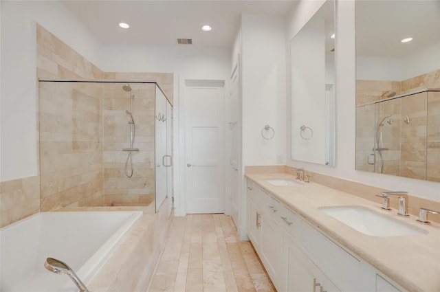 full bath featuring a stall shower, a garden tub, a sink, and visible vents