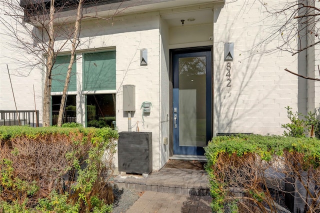 doorway to property featuring brick siding