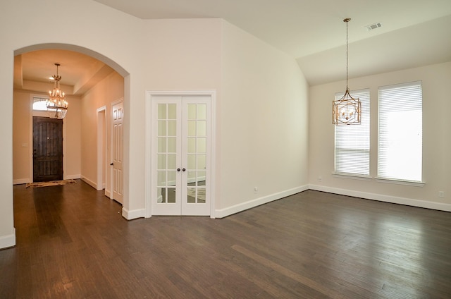 empty room featuring an inviting chandelier, dark hardwood / wood-style flooring, and a healthy amount of sunlight