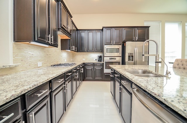 kitchen featuring dark brown cabinetry, sink, tasteful backsplash, and stainless steel appliances