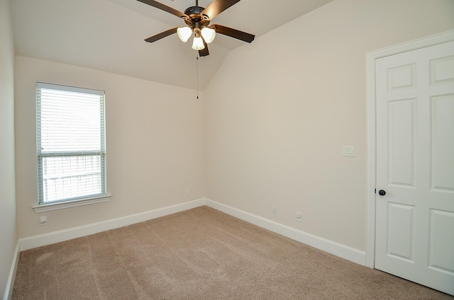 spare room with lofted ceiling, light carpet, and ceiling fan