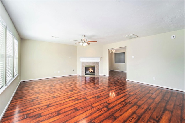 unfurnished living room featuring visible vents, baseboards, a ceiling fan, a premium fireplace, and dark wood-style flooring