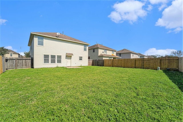 back of house featuring a fenced backyard and a yard