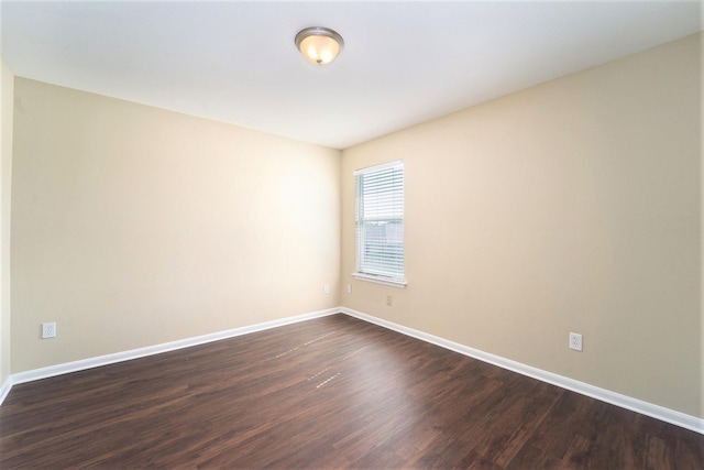 unfurnished room with dark wood-style floors and baseboards