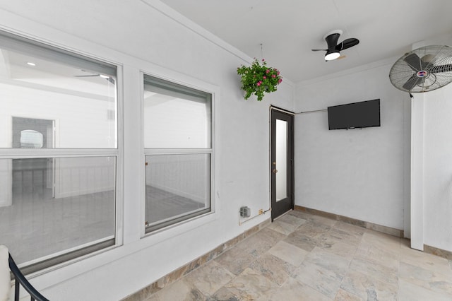 unfurnished sunroom with ceiling fan