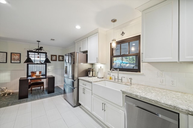 kitchen with sink, decorative light fixtures, stainless steel appliances, light stone countertops, and white cabinets