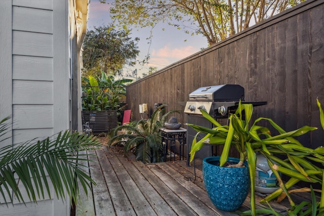 deck at dusk featuring grilling area