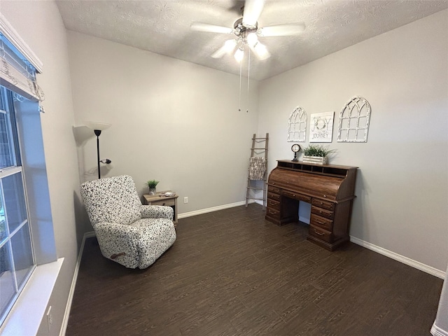 sitting room featuring dark wood-type flooring, ceiling fan, and a textured ceiling