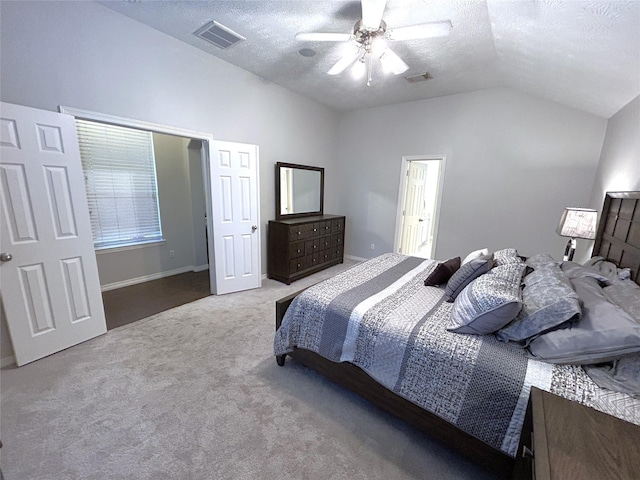 carpeted bedroom featuring ceiling fan, vaulted ceiling, and a textured ceiling