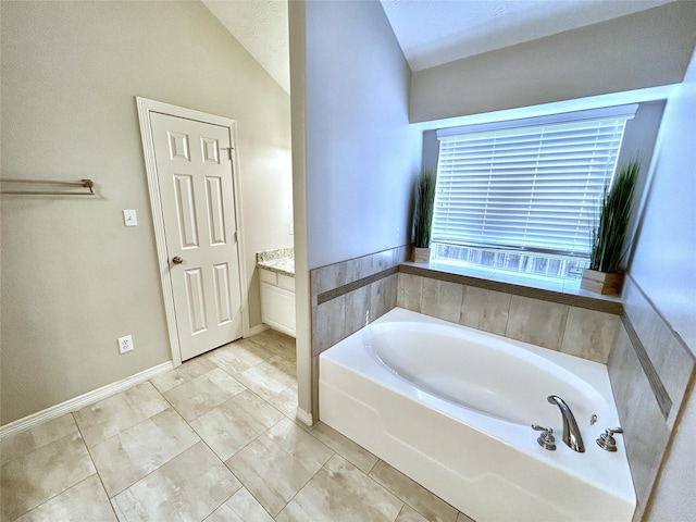 bathroom with vanity, vaulted ceiling, and a washtub