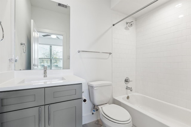 full bathroom with tiled shower / bath, vanity, and toilet