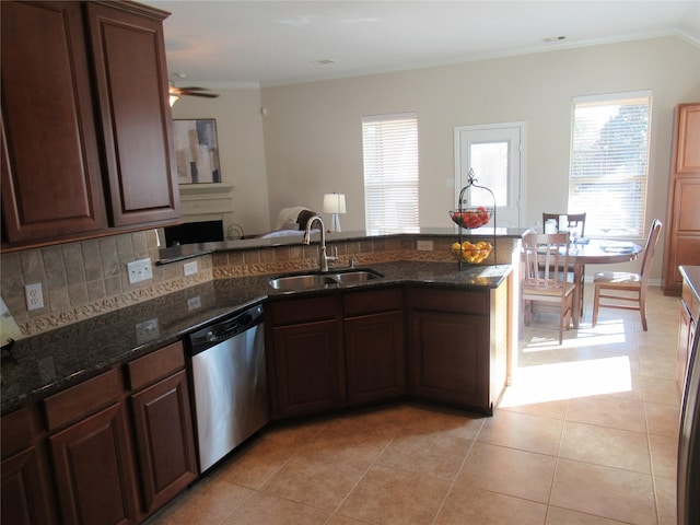 kitchen with dishwasher, sink, dark stone countertops, and a wealth of natural light