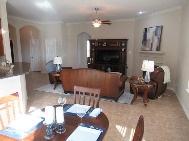 tiled dining area featuring crown molding and ceiling fan